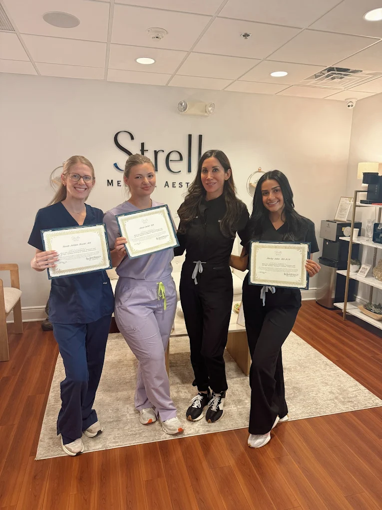 Strella Medical Aesthetics team members holding aesthetic training certificates inside the Trooper, PA medical spa.